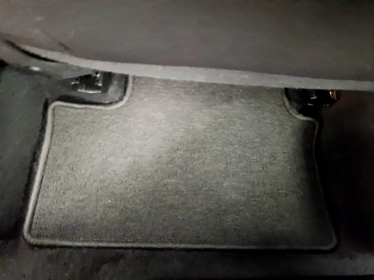 Tapis de sol gris foncé sous le siège avant d'une Renault Clio Business E-Tech hybride 2021, vue intérieure rapprochée.