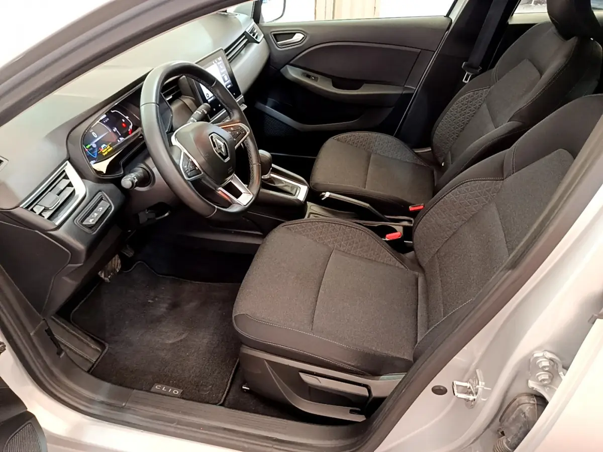 Intérieur avant droit de la Renault Clio Business E-Tech hybride gris clair, sièges tissu noir et tableau de bord moderne.