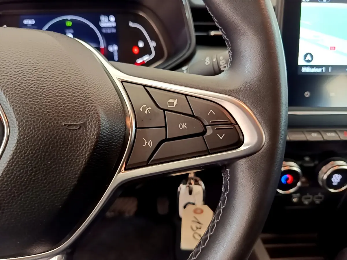Gros plan sur le volant noir de la Renault Clio Business E-Tech hybride 2021 avec commandes multifonctions visibles.