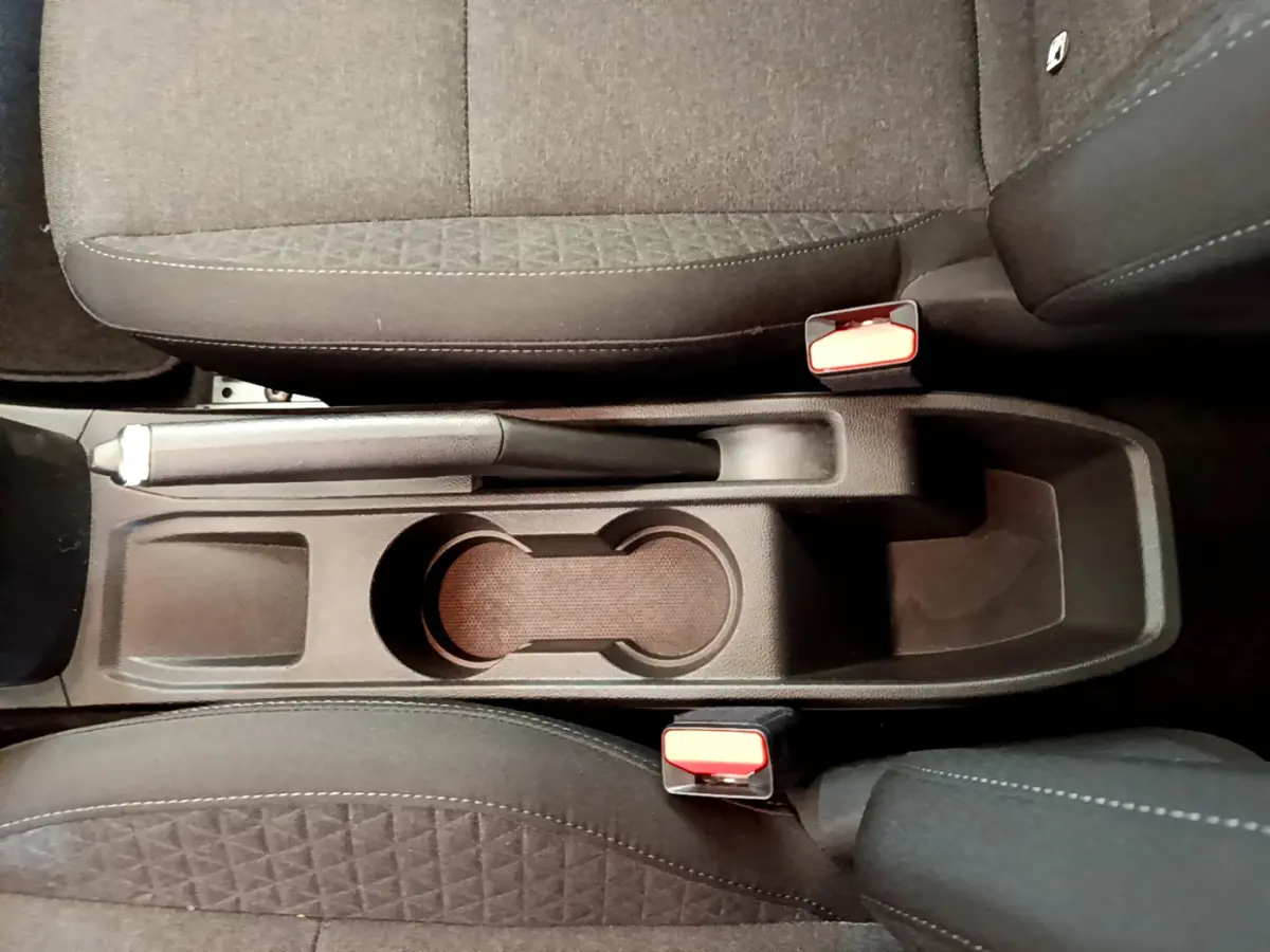 Vue plongeante sur la console centrale noire entre les sièges avant gris foncé de la Renault Clio Business E-Tech hybride 2021.