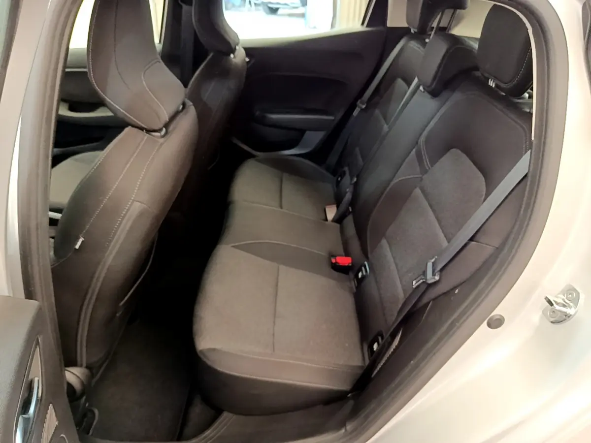 Vue côté droit de l'habitacle arrière d'une Renault Clio Business E-Tech hybride gris clair avec sièges tissu noirs.