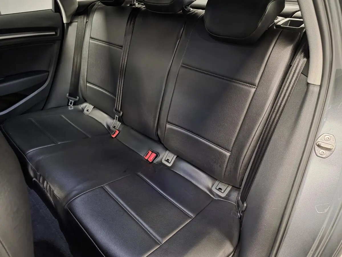 Vue intérieure du siège arrière en similicuir noir de l'Audi A3 Sportback gris, côté droit ouvert.