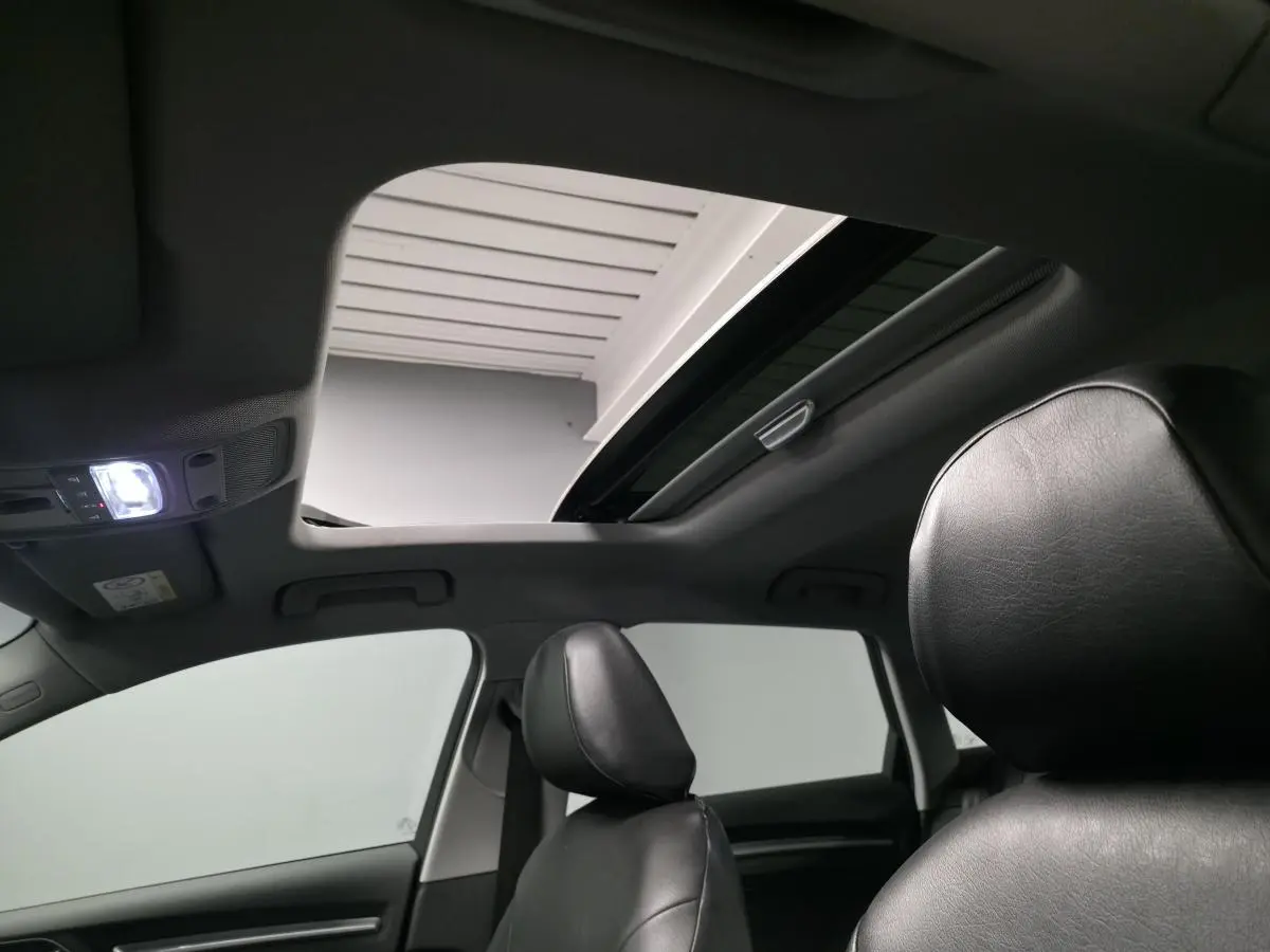 Intérieur d'Audi A3 Sportback 2017, vue sur toit panoramique ouvert et sièges avant en similicuir noir.