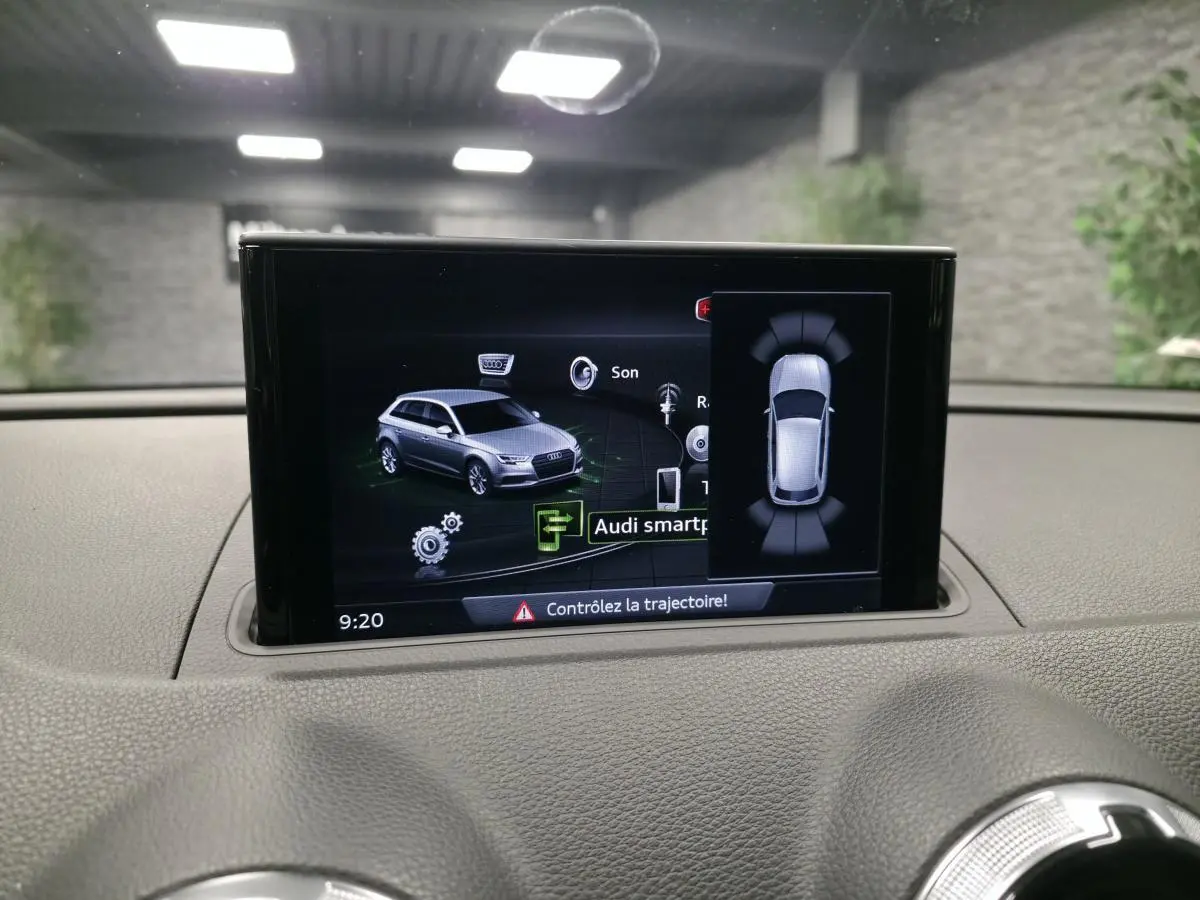 Écran central affichant l'interface Audi smartphone dans un Audi A3 Sportback gris, vue intérieure tableau de bord.