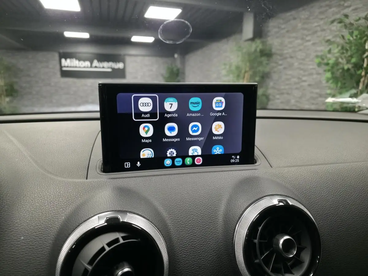 Écran tactile central affichant des applications, sur le tableau de bord gris d'une Audi A3 Sportback 2017.