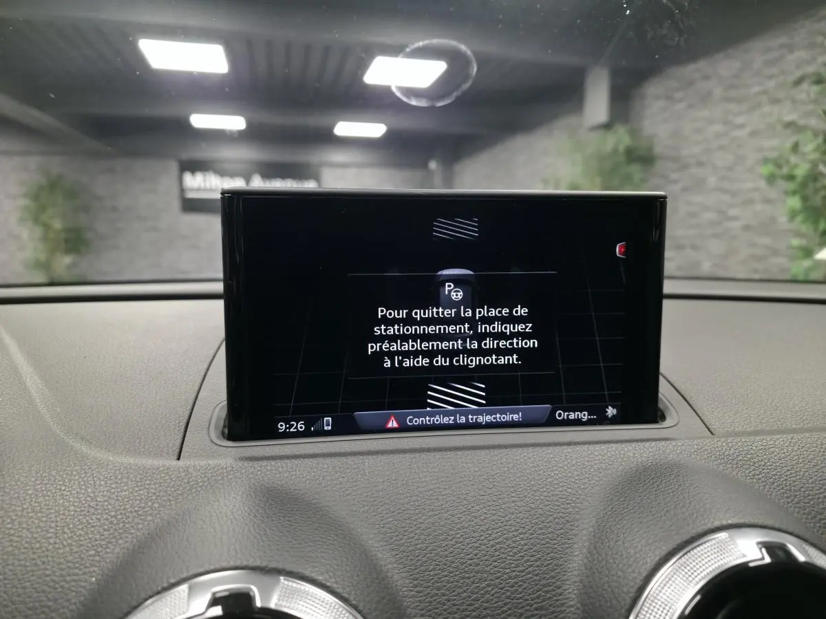 Écran central du tableau de bord de l'Audi A3 gris 2017 affichant les instructions du système d'aide au stationnement.