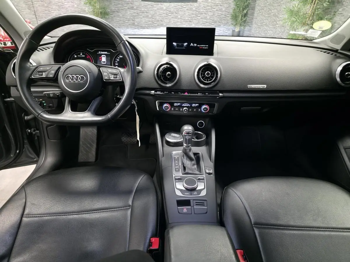 Intérieur noir de l'Audi A3 Sportback 2017, vue de face sur le tableau de bord et le volant multifonction.