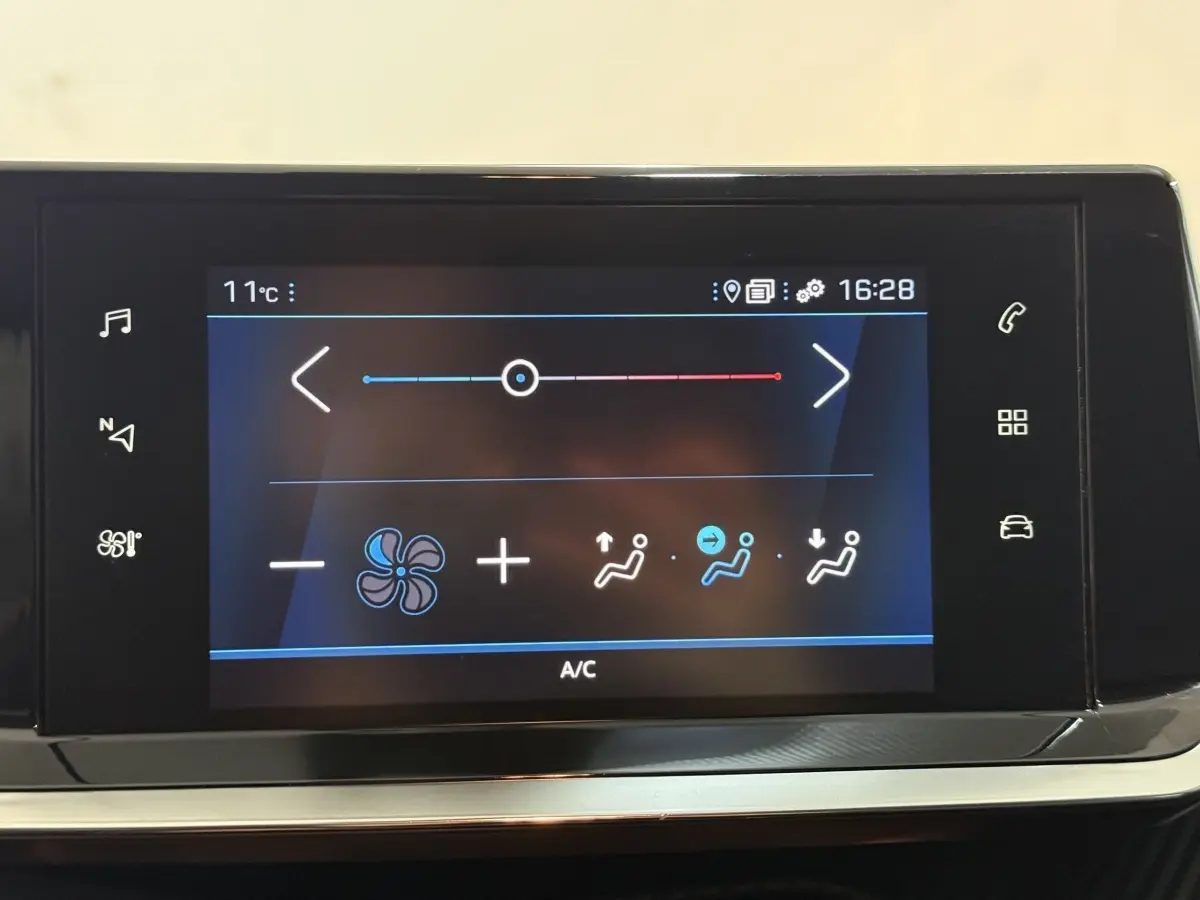Écran tactile central du tableau de bord de la Peugeot 208 blanc, affichant les réglages de climatisation.