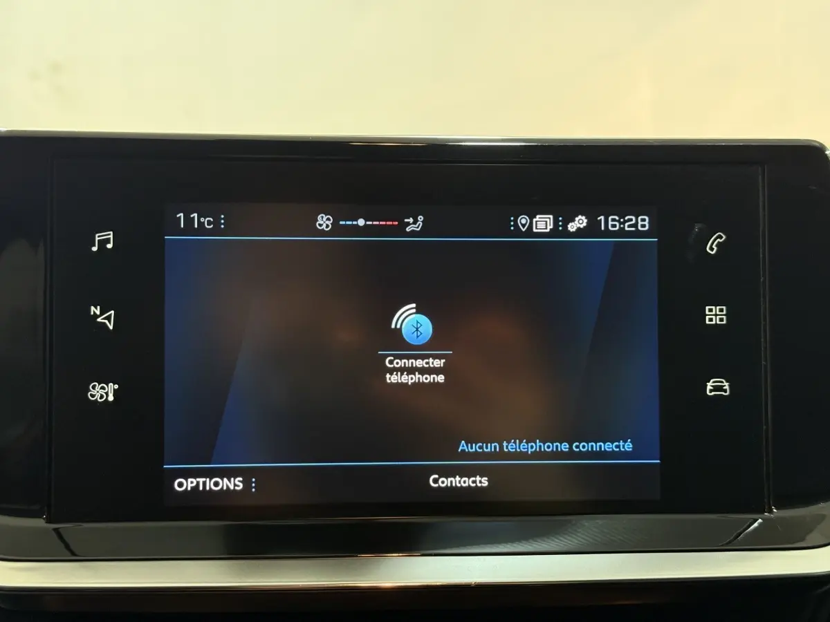 Écran tactile central de la Peugeot 208 blanc, affichant la connexion Bluetooth pour téléphone, vue de face.