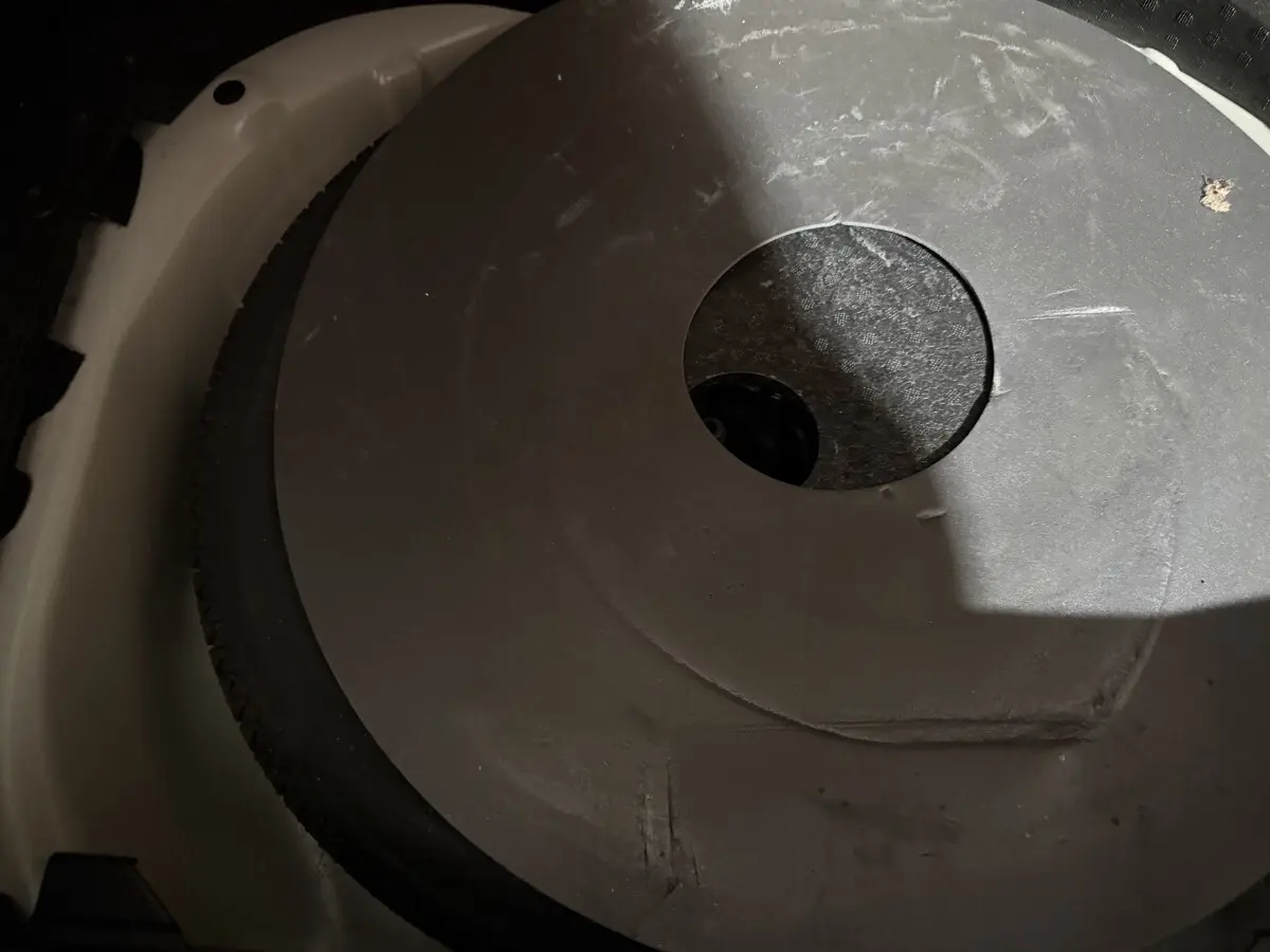 Gros plan sur la roue de secours noire dans le coffre blanc d'une Peugeot 208 1.5 BlueHDi 2021.