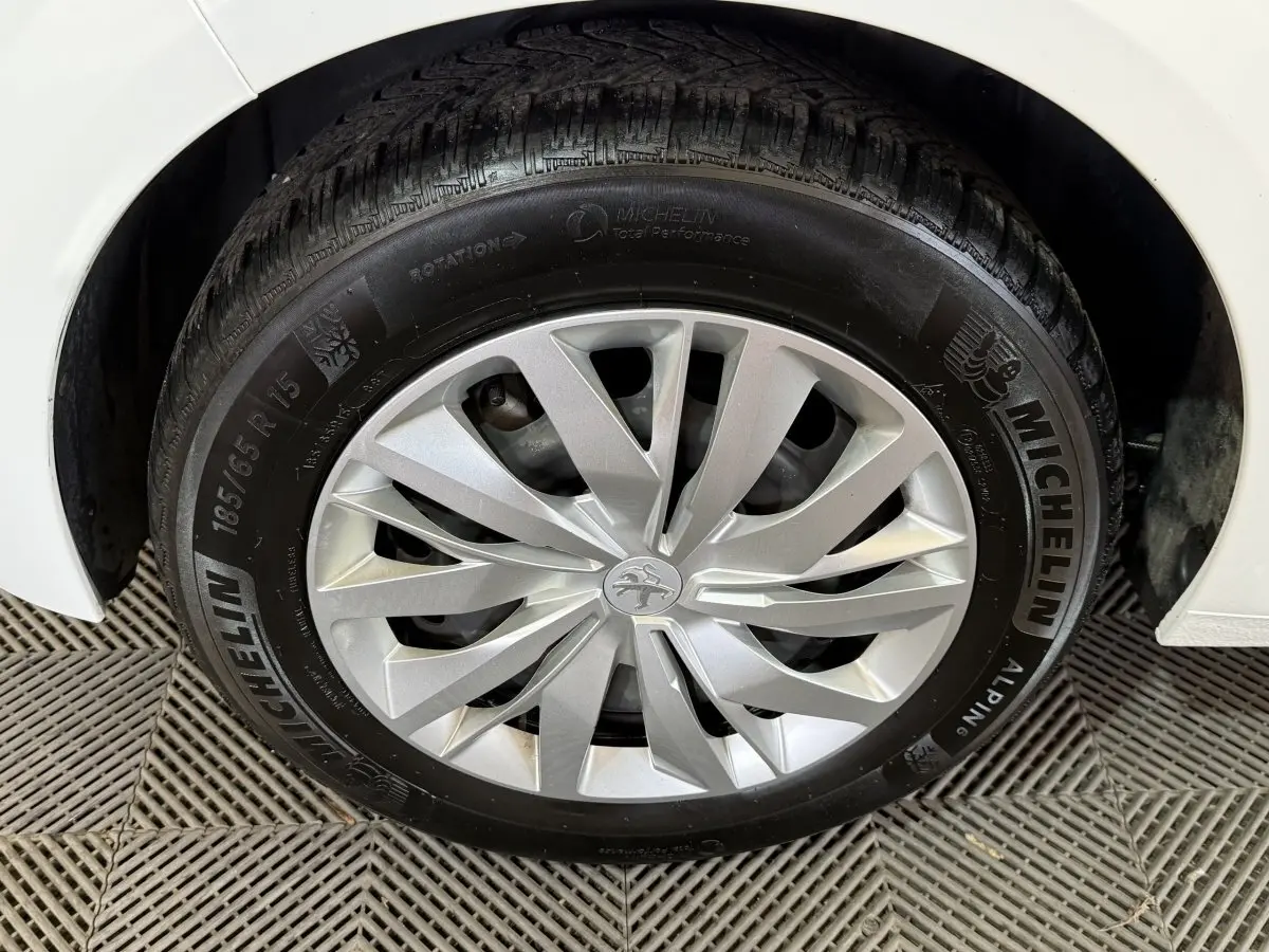 Gros plan sur la roue avant droite blanche d'une Peugeot 208 1.5 BlueHDi avec jante argentée et pneu Michelin.