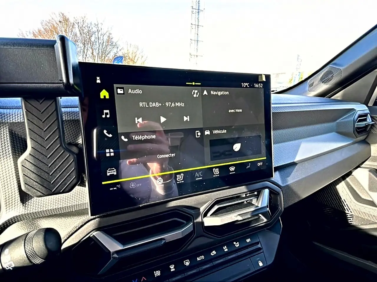 Vue intérieure du tableau de bord du Dacia Duster 2026, écran tactile multifonction et aérateurs angulaires noirs.