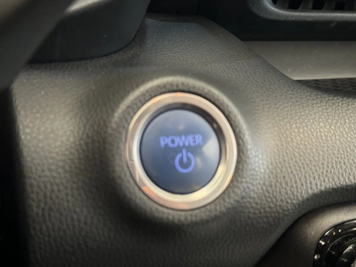Bouton démarrage Power en gros plan sur tableau de bord noir d'une Toyota Yaris hybride blanche 2022