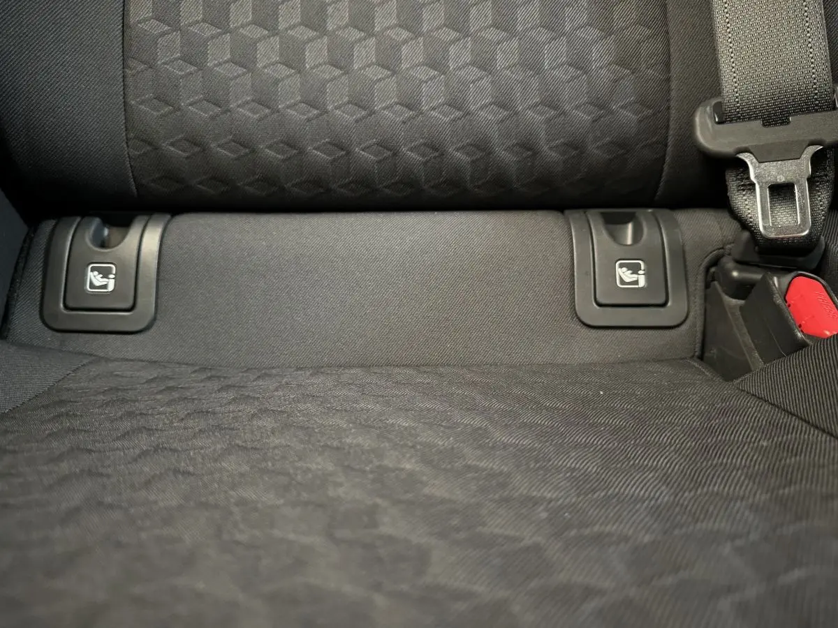Gros plan sur la banquette arrière noire de la Toyota Yaris hybride 2022 avec fixations Isofix visibles et ceinture de sécurité.