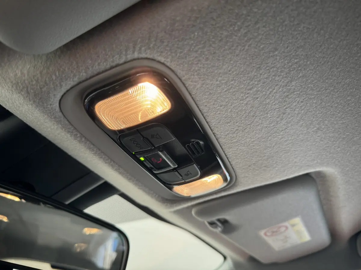 Plafonnier intérieur allumé avec commandes SOS et éclairages de lecture dans une Toyota Yaris blanche hybride 2022