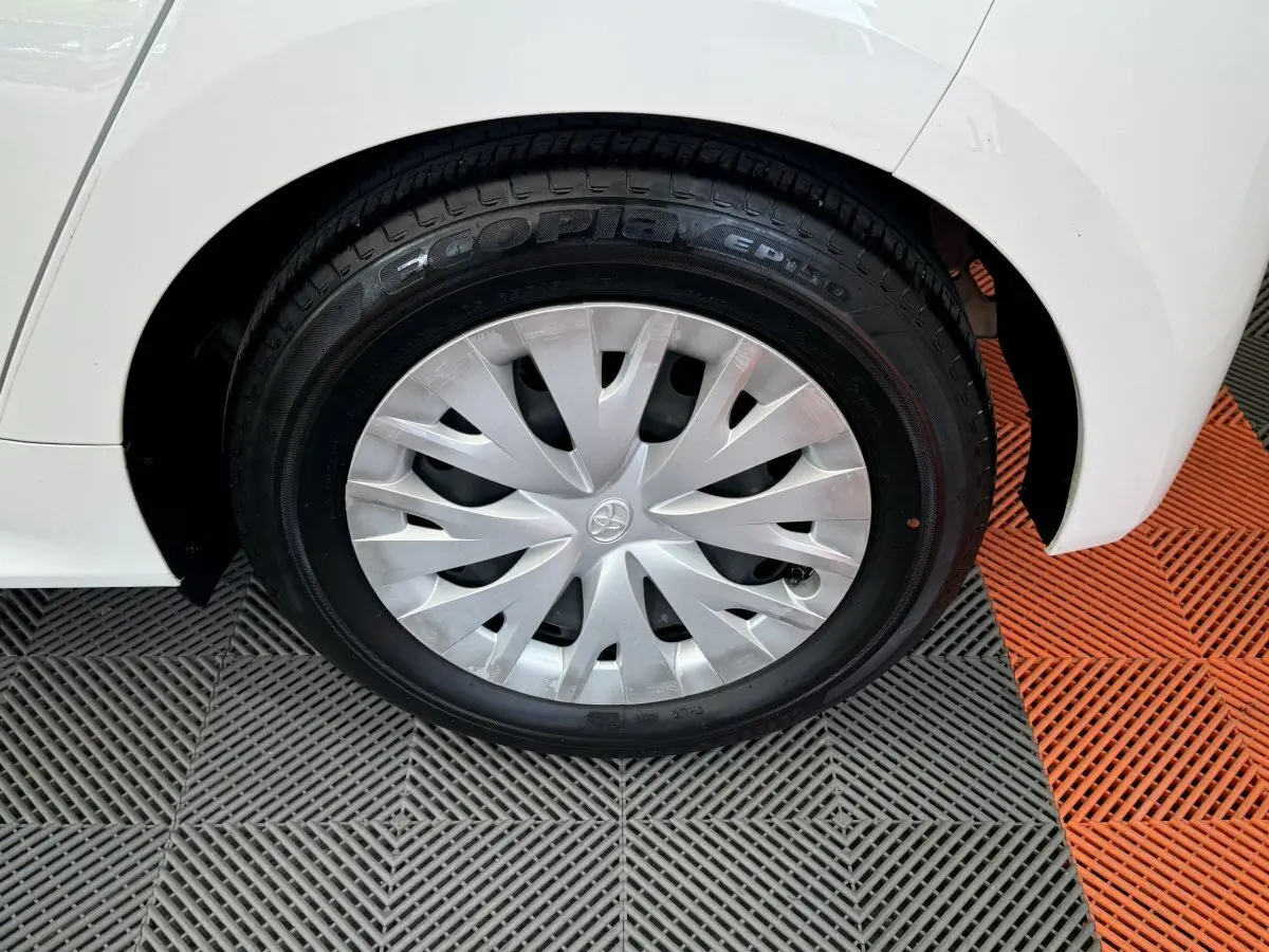 Gros plan sur la roue arrière droite blanche d'une Toyota Yaris hybride 2022 avec enjoliveur argenté et pneu Ecopia.