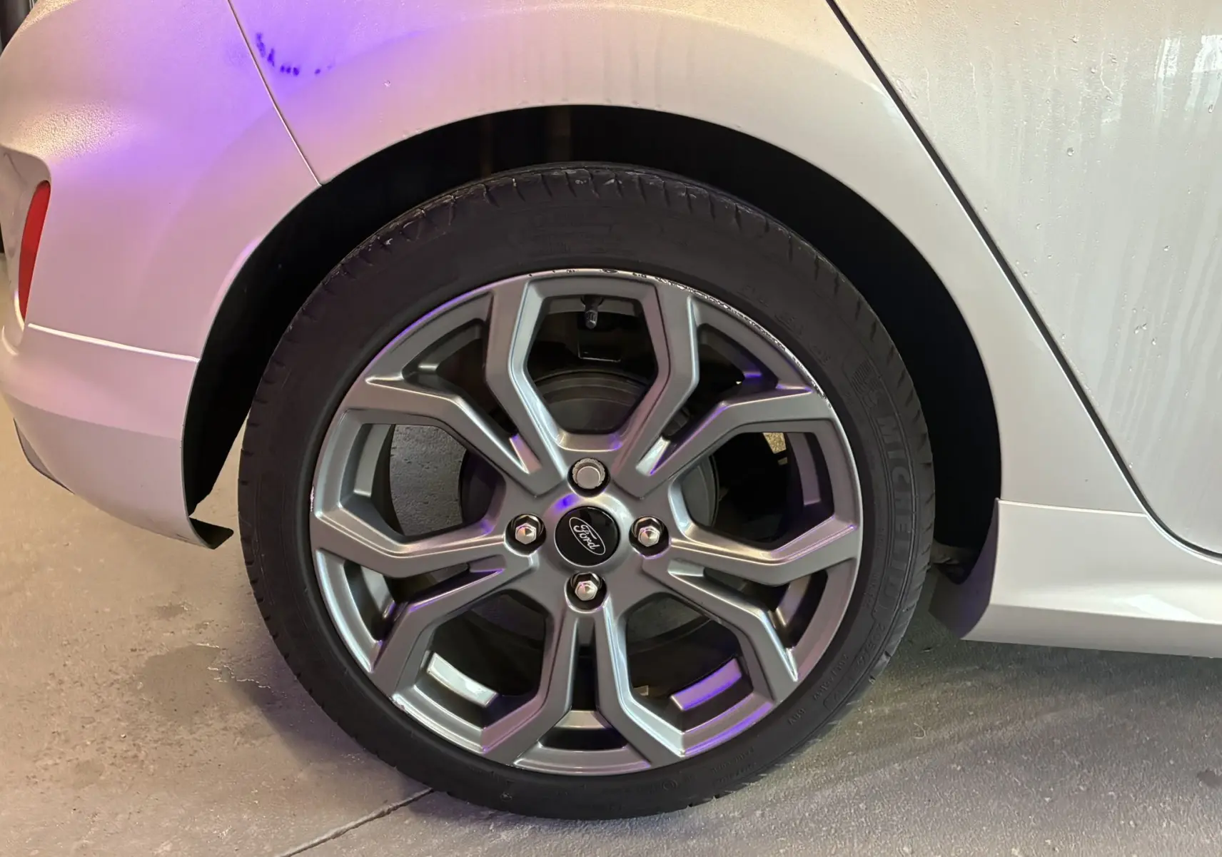 Gros plan sur la roue arrière gauche grise d'une Ford Fiesta 1.0 EcoBoost 95 ST Line avec jante alliage 17 pouces.