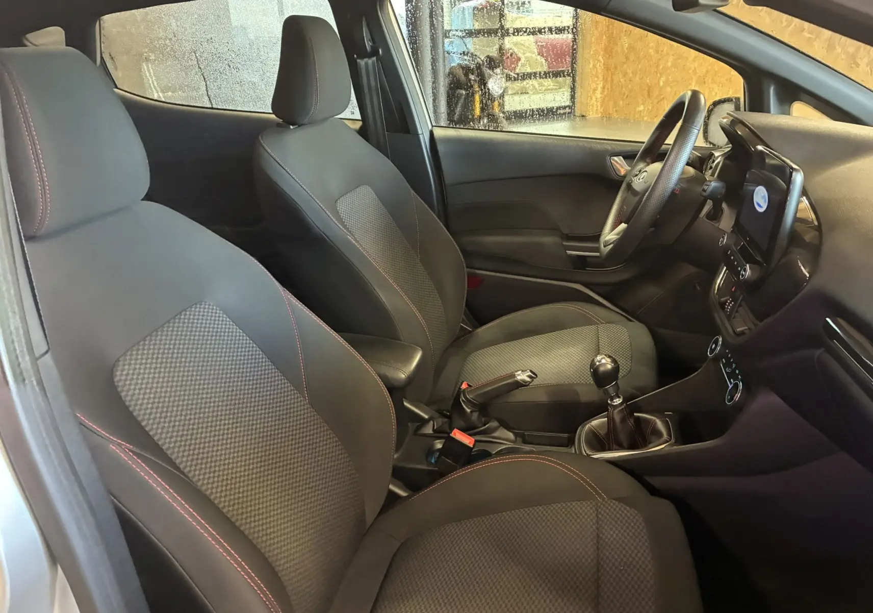 Intérieur de la Ford Fiesta 1.0 EcoBoost 95 ST Line 2020, vue côté droit sur sièges tissu gris noir et tableau de bord.