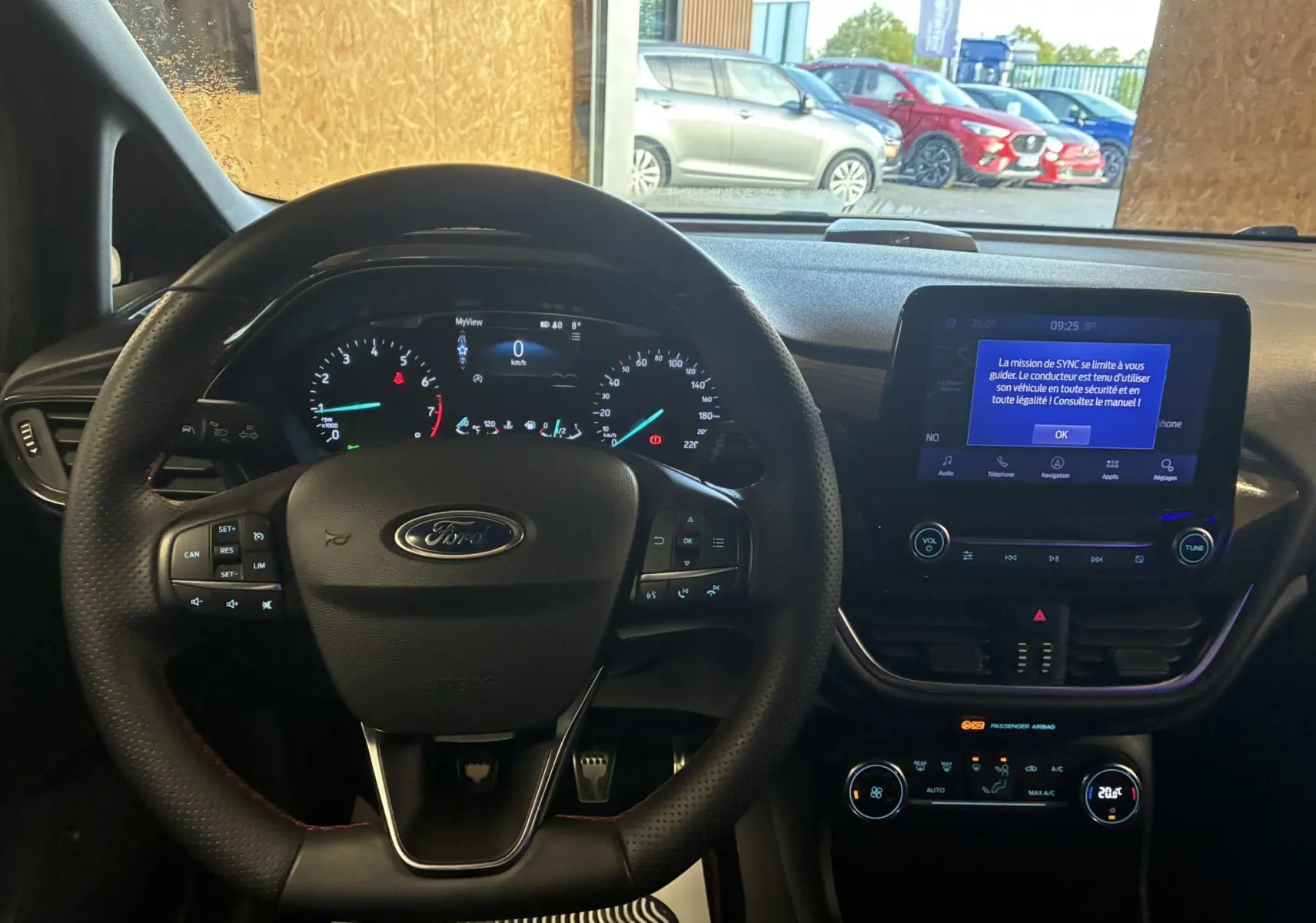 Vue intérieure du tableau de bord et volant Ford Fiesta 2020 gris, avec écran tactile et commandes au volant visibles.