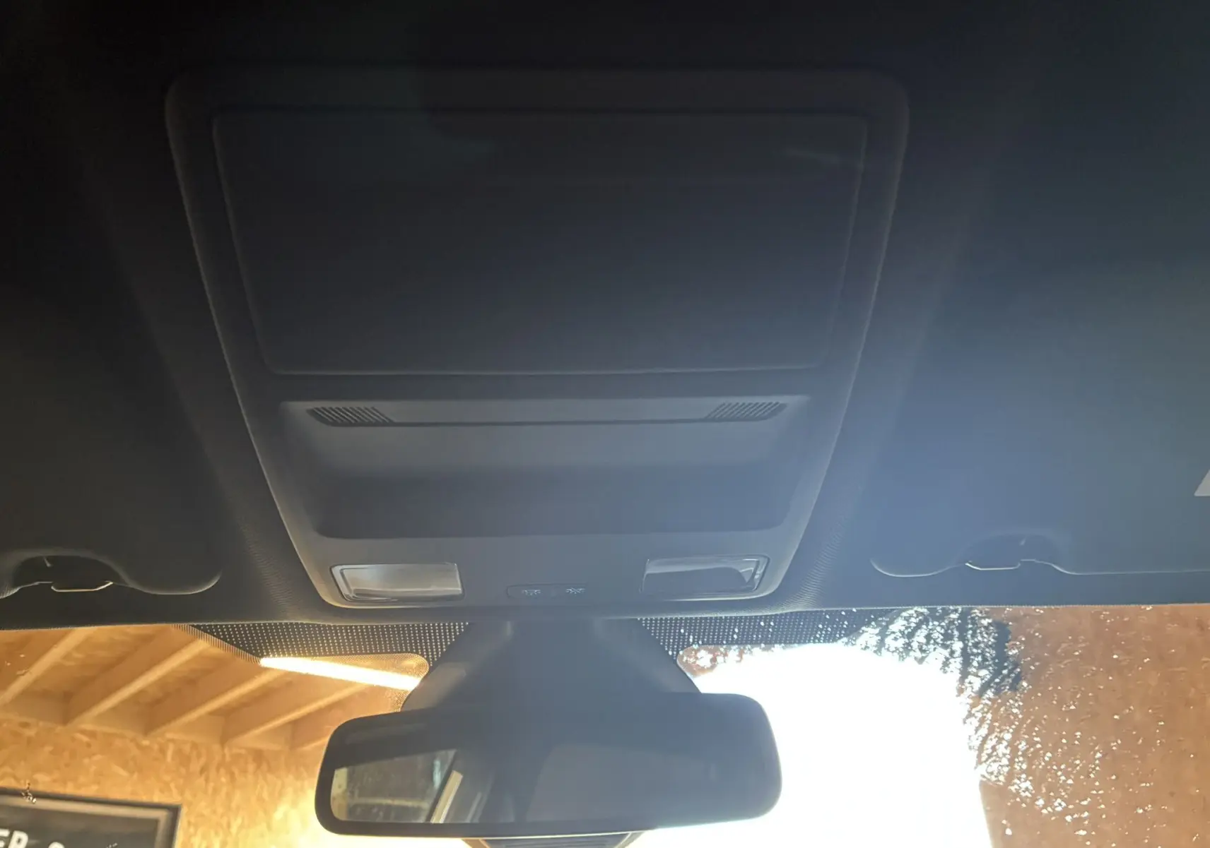 Vue intérieure du toit ouvrant et du rétroviseur central d'une Ford Fiesta gris foncé, ambiance sobre et moderne.