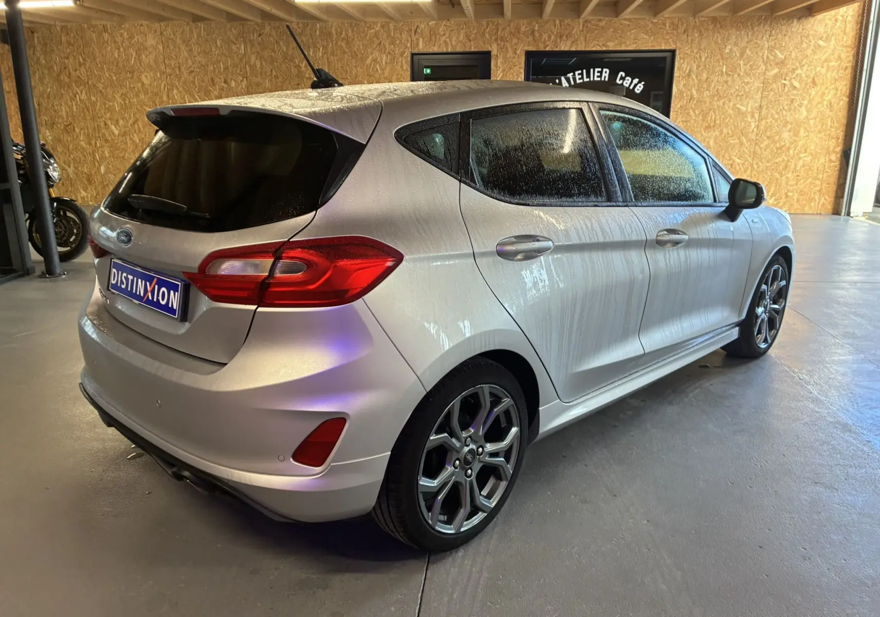 Ford Fiesta 1.0 EcoBoost ST Line gris vue 3/4 arrière droit en intérieur, avec jantes alliage et vitres teintées.