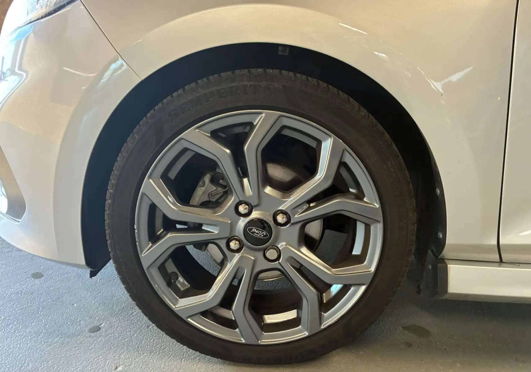 Gros plan sur la roue avant gauche grise d'une Ford Fiesta 1.0 EcoBoost 95 ST Line avec jante alliage distinctive.