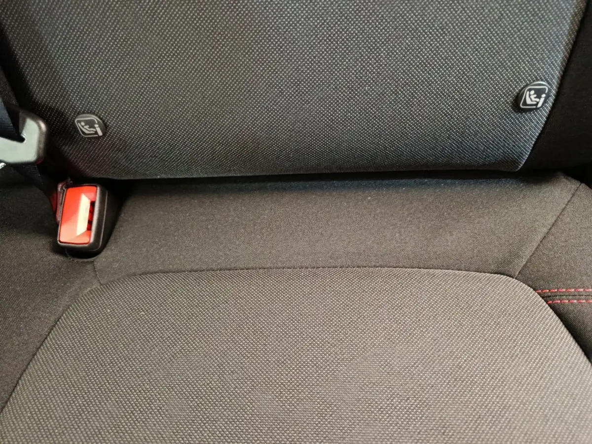Gros plan sur la banquette arrière noire du Ford Puma 2025 avec fixation Isofix et ceinture rouge visible.