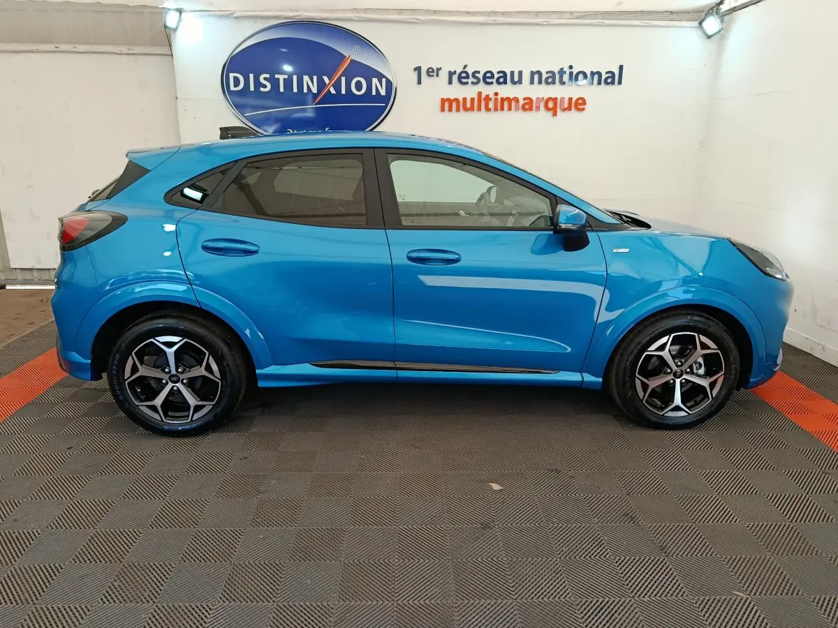 Ford Puma 2025 bleu en profil côté gauche, avec jantes alliage noires et logo ST-LINE visible sur l'aile avant.