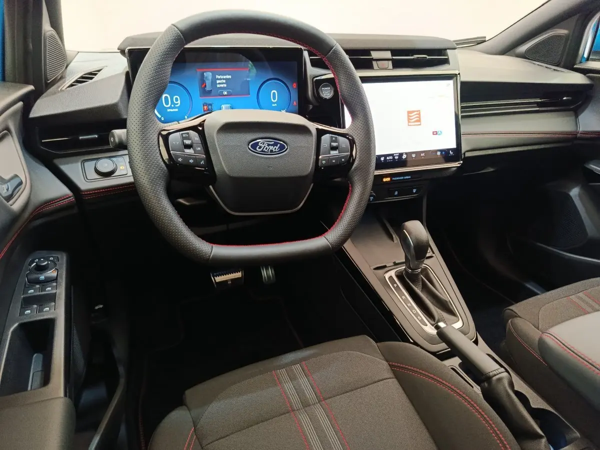 Intérieur du Ford Puma 2025 ST-LINE, vue du poste de conduite avec volant cuir, écran tactile central et tableau de bord numérique.