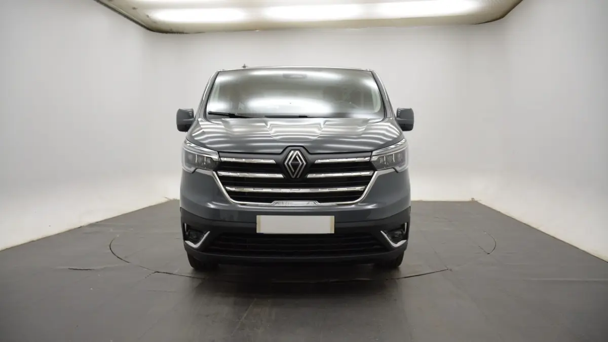 Vue frontale du Renault Trafic Fourgon gris clair 2025 avec calandre chromée et phares LED ellipsoïdaux.