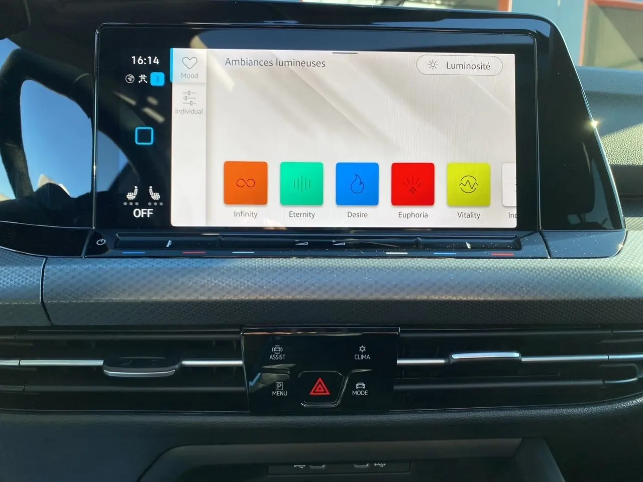 Vue rapprochée de l’écran tactile central de la Volkswagen Golf VIII noire, affichant les options d’ambiances lumineuses.