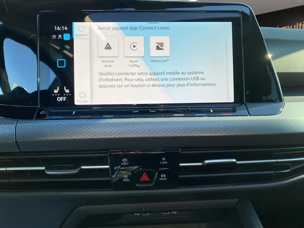 Vue rapprochée de l’écran tactile central et de la console de la Volkswagen Golf VIII noire avec commandes climatisation et connectivité smartphone.