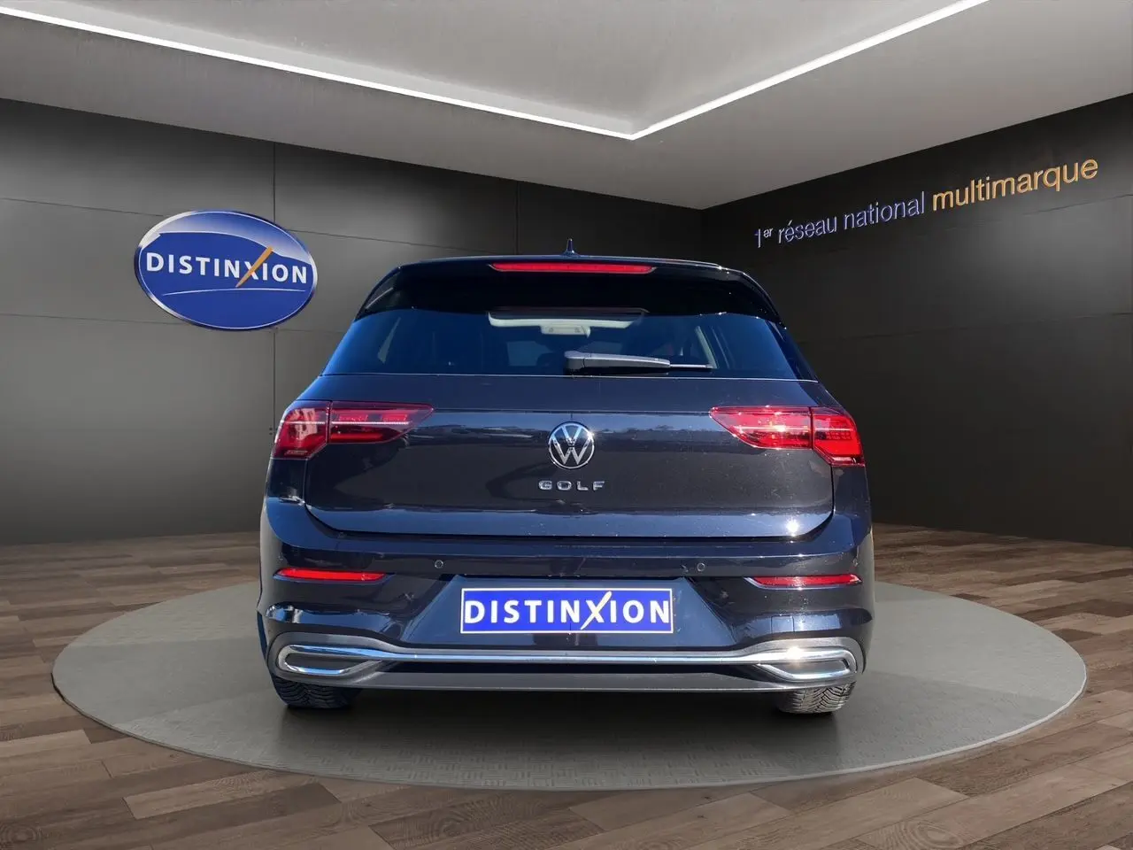 Vue arrière d'une Volkswagen Golf VIII noire intense nacrée, avec feux LED et attelage escamotable visible.