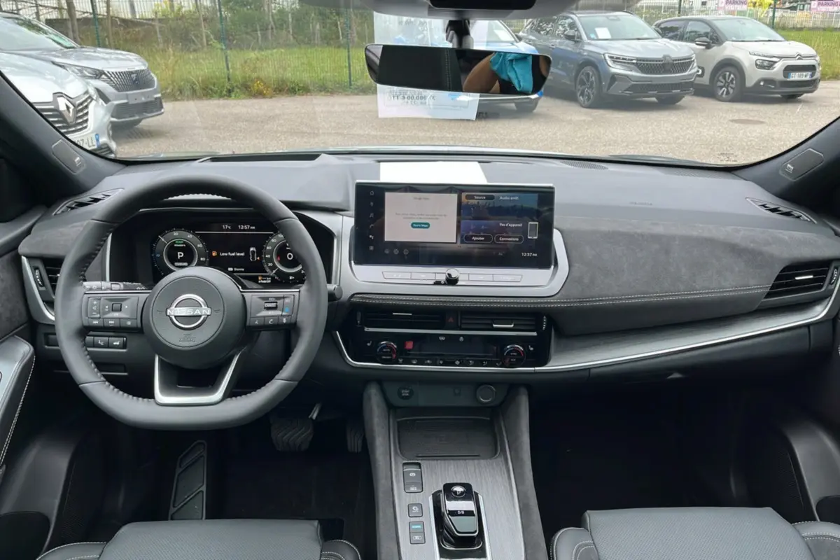 Vue intérieure frontale du Nissan Qashqai E-POWER 205 Tekna Plus 2026, tableau de bord moderne avec écran tactile et volant cuir multifonctions.