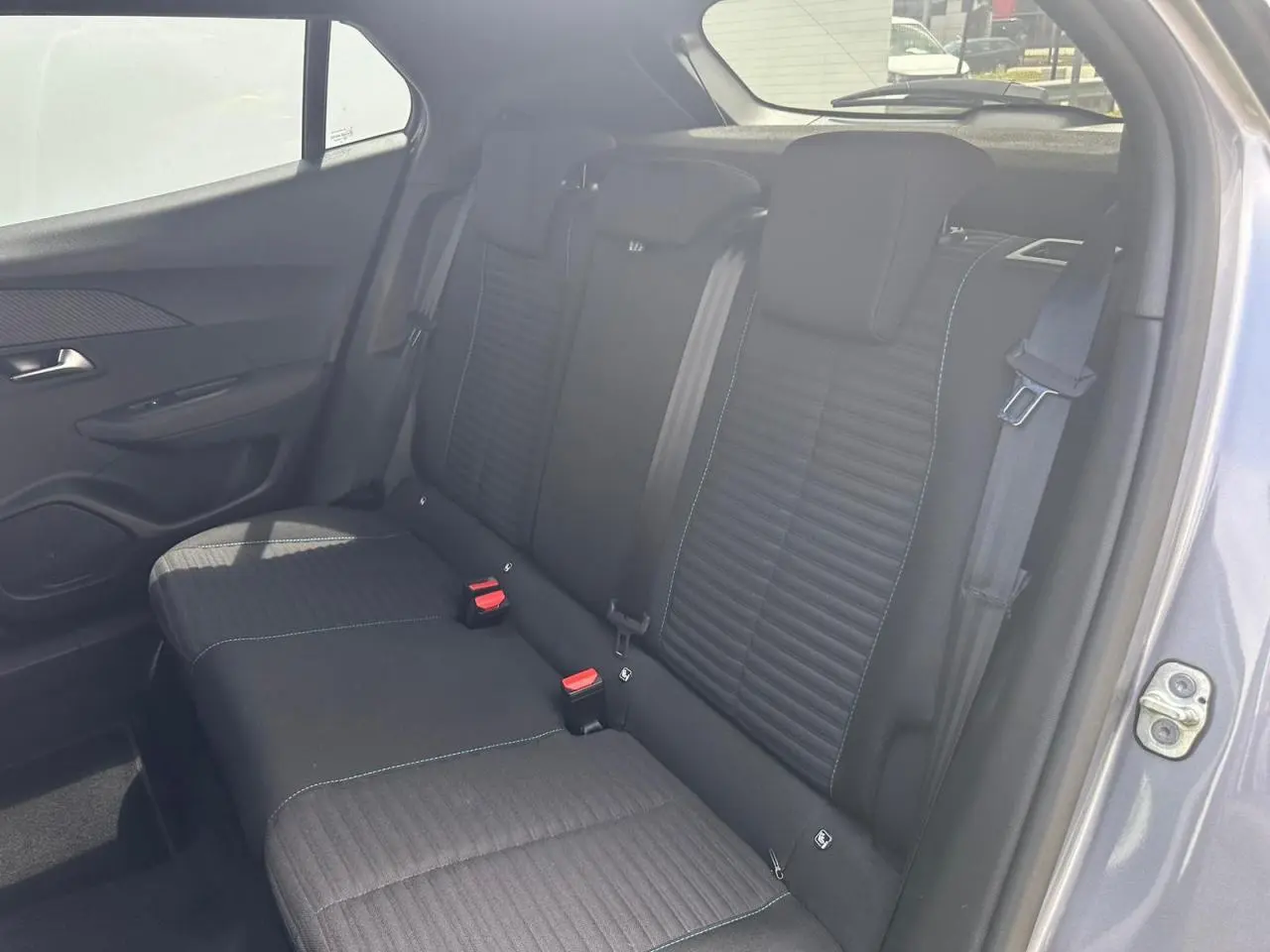 Vue intérieure côté droit de la banquette arrière noire avec surpiqûres bleu azur du Peugeot 2008 gris clair 2022