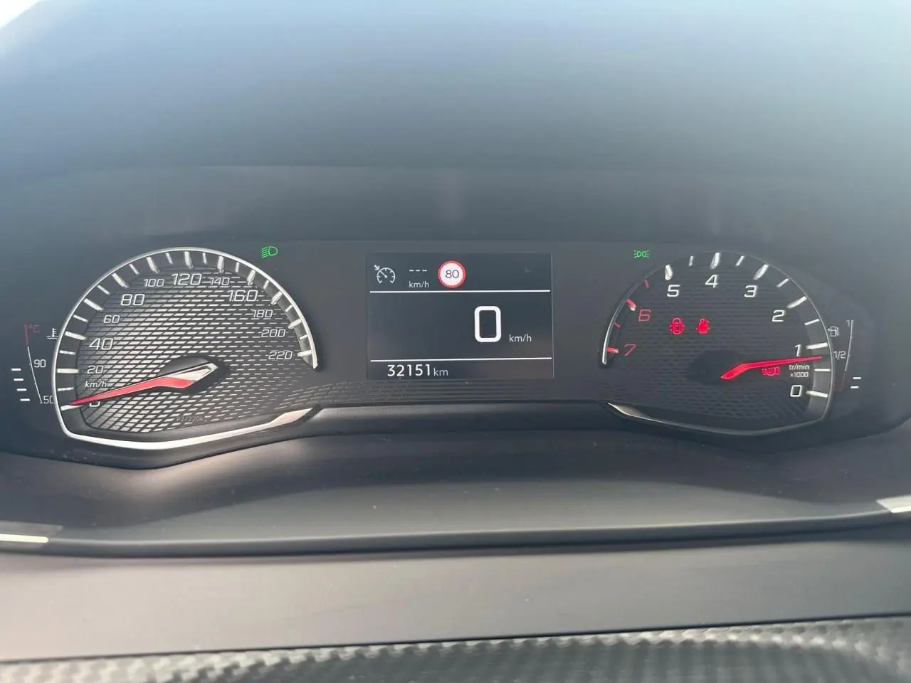 Tableau de bord du Peugeot 2008 gris clair 2022, affichage digital avec compteur vitesse à 0 km/h et 32151 km.