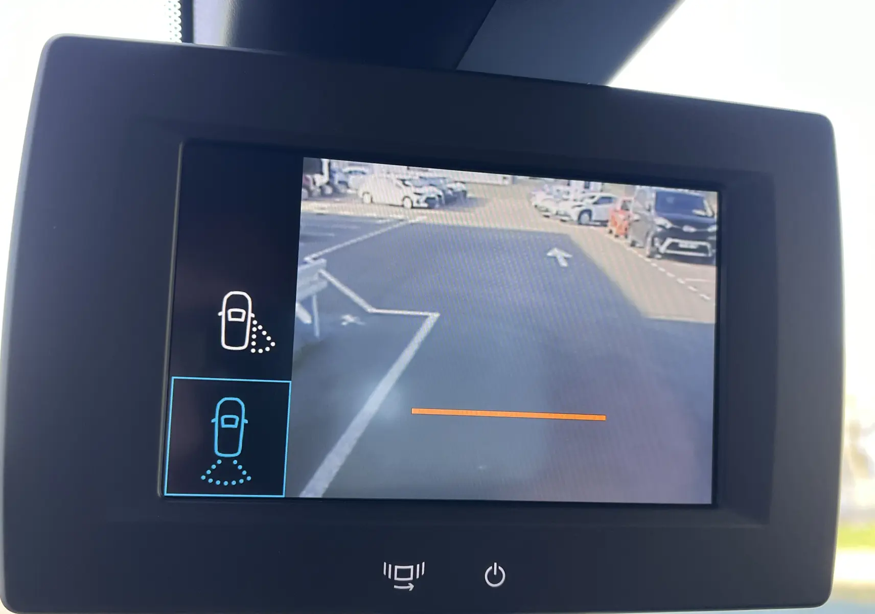 Écran de caméra de recul affichant une vue arrière du parking avec plusieurs véhicules visibles, dans un Toyota Proace City blanc.