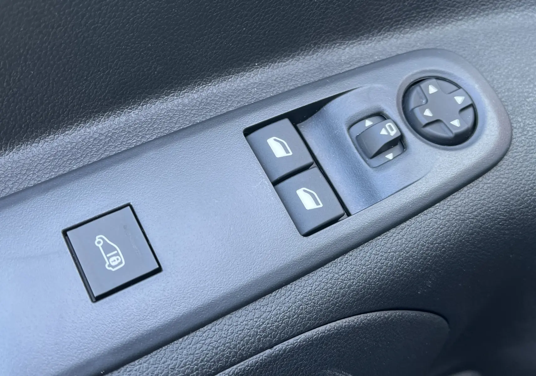 Boutons de commande des vitres et rétroviseurs sur la porte côté conducteur d'un Toyota Proace City blanc glacier 2023.