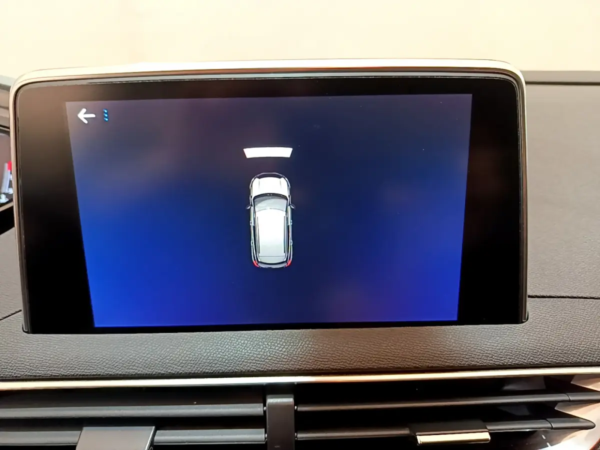 Écran tactile central du Peugeot 3008 noir de 2019 montrant l'alerte de proximité du véhicule en stationnement.