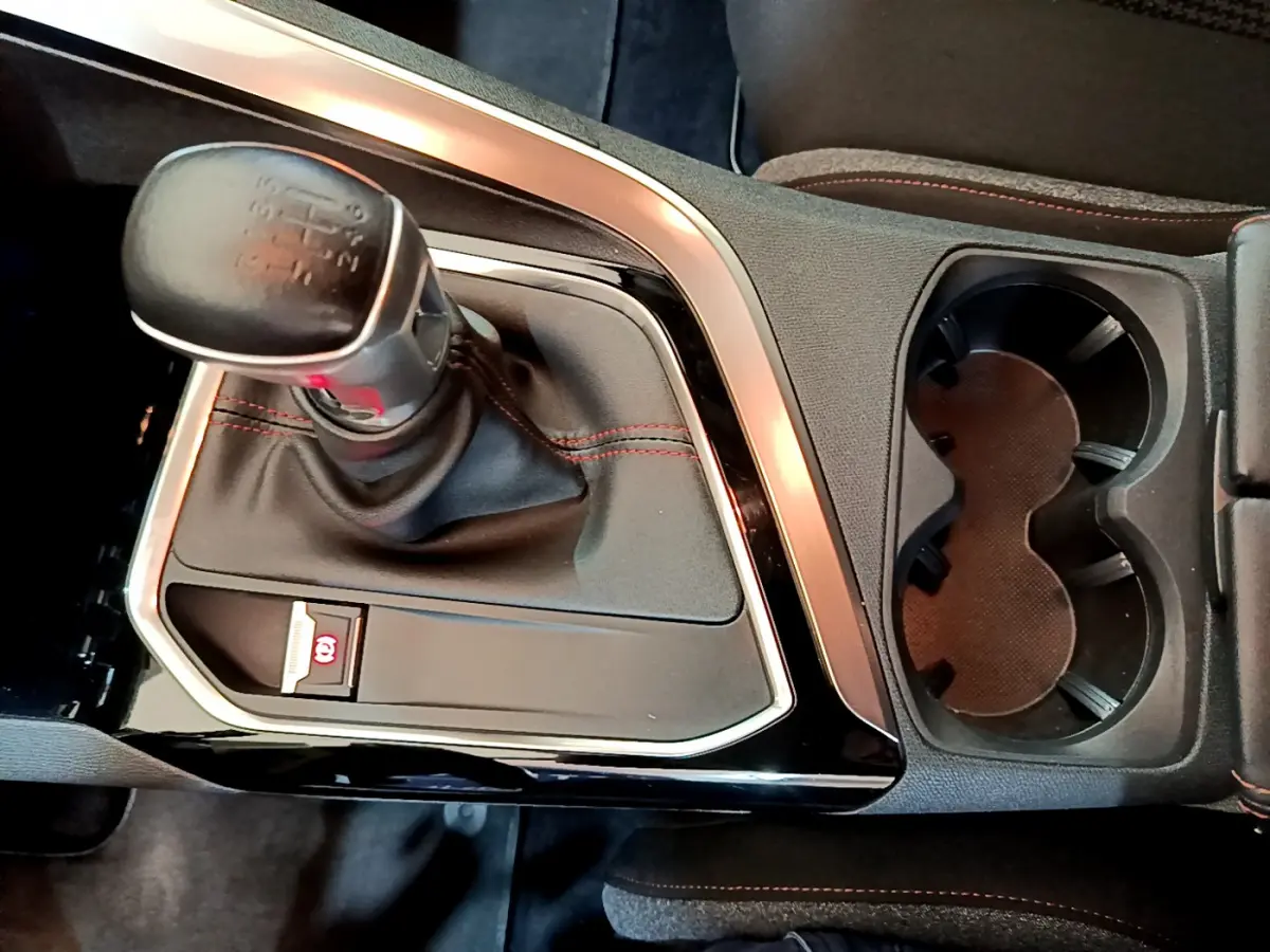 Gros plan sur la console centrale du Peugeot 3008 noir, mettant en valeur le levier de vitesse manuel et les porte-gobelets.