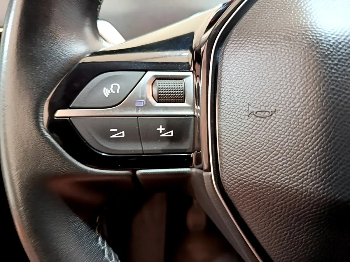 Gros plan sur les commandes gauche du volant cuir noir du Peugeot 3008 2019 version BlueHDi Active Business.