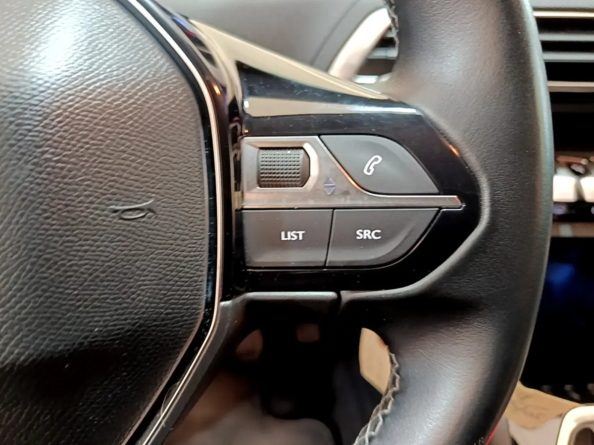 Gros plan sur les commandes gauche du volant cuir noir du Peugeot 3008 2019, boutons de gestion audio et appel.