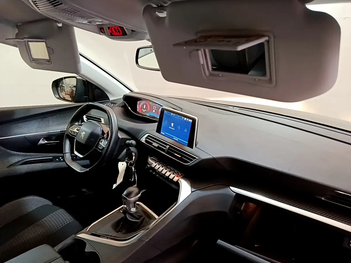 Intérieur Peugeot 3008 noir vu côté conducteur, tableau de bord moderne avec écran tactile et volant cuir multifonctions.