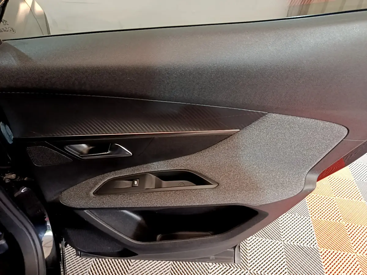 Vue rapprochée de la porte côté gauche du Peugeot 3008 noir, avec insert décoratif et commande de vitre électrique.