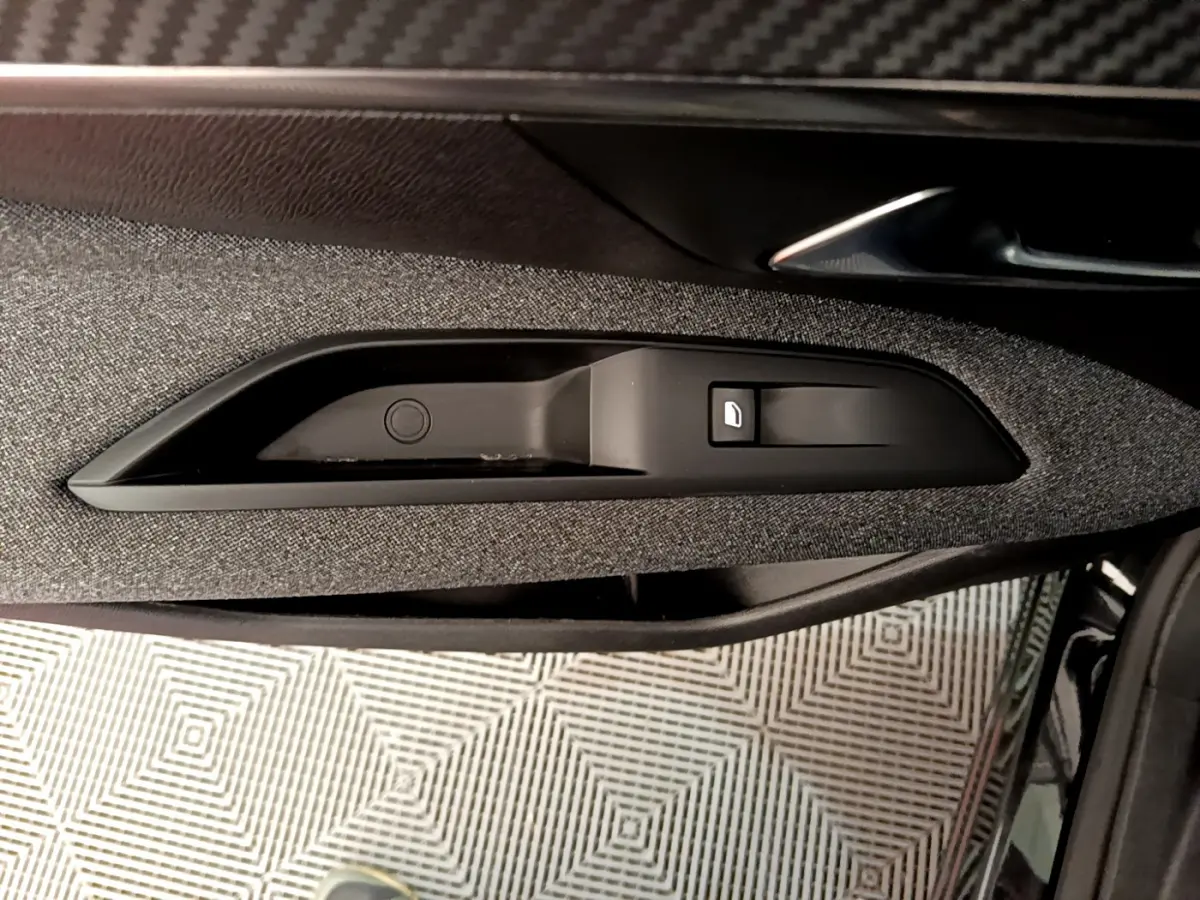 Poignée intérieure côté gauche de porte avec bouton verrouillage, tissu gris et garniture noire du Peugeot 3008 noir 2019.