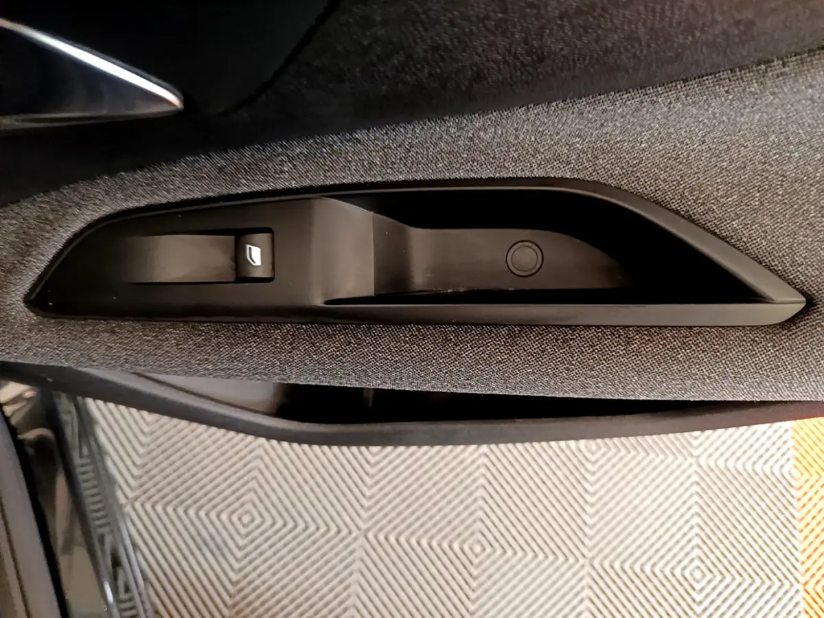 Détail de la commande de lève-vitre côté conducteur sur la porte intérieure d'un Peugeot 3008 noir de 2019.