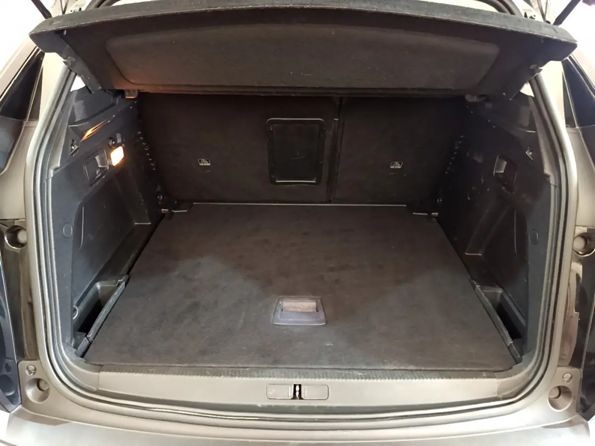 Coffre ouvert d'un Peugeot 3008 noir, vue de l'arrière montrant un espace de chargement propre et spacieux.