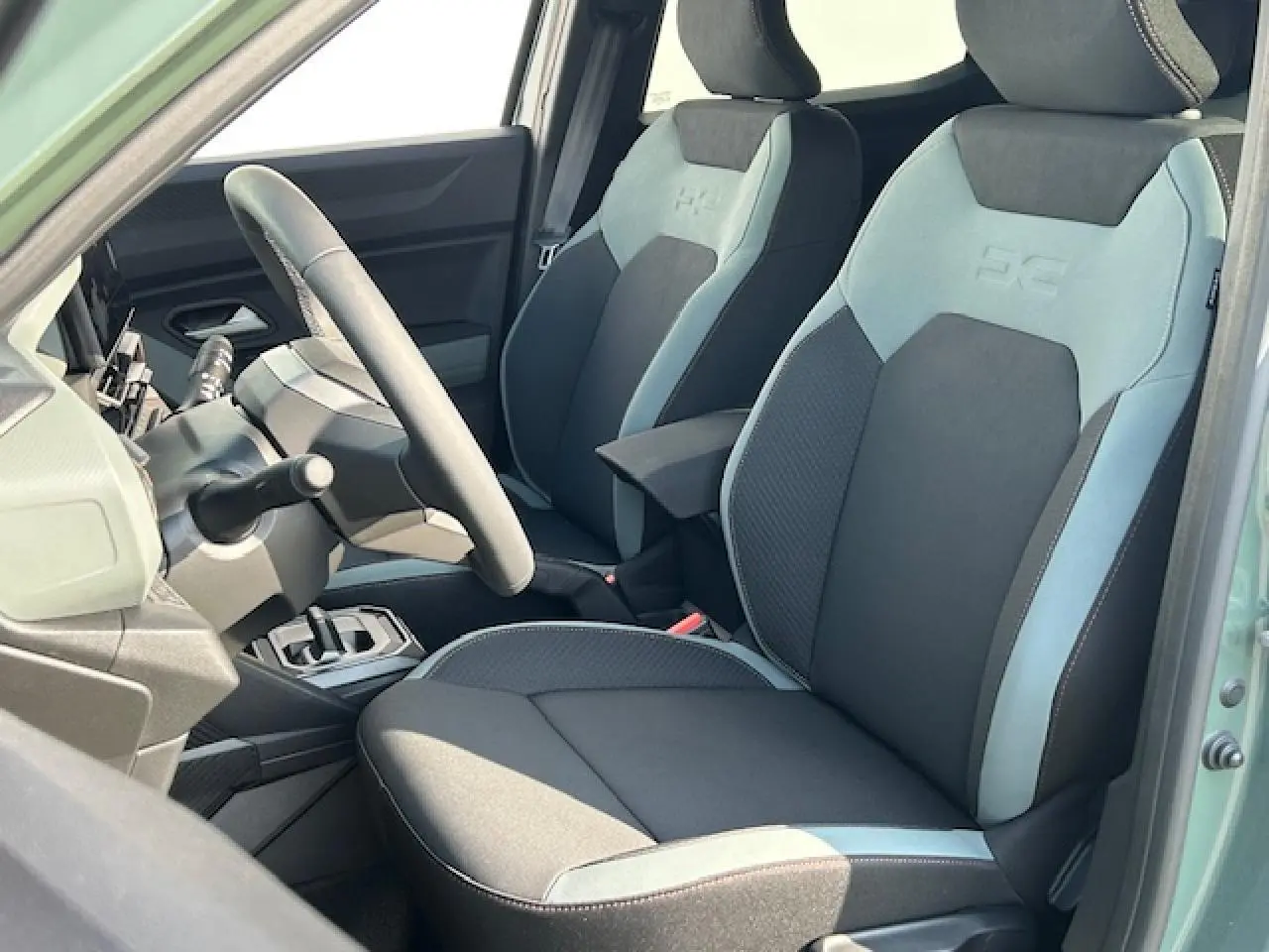 Intérieur du Dacia Duster III 2025 en kaki lichen, vue côté conducteur sur sièges TEP MicroCloud et volant soft feel.