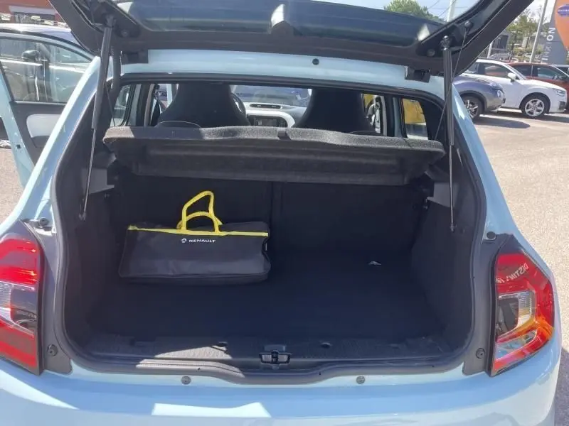 Coffre ouvert vu de l'arrière d'une Renault Twingo III bleu dragée 2022 avec sac noir et jaune Renault à l'intérieur.