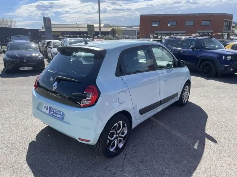 Vue 3/4 arrière droite d'une Renault Twingo III bleu dragée 2022 avec toit noir et jantes distinctives.